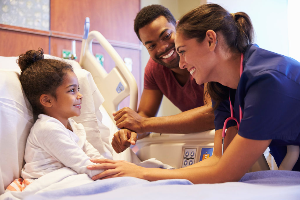 Pediatrician Visiting Father And Child In Hospital Bed